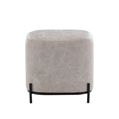 a white ottoman sitting on top of a metal stand