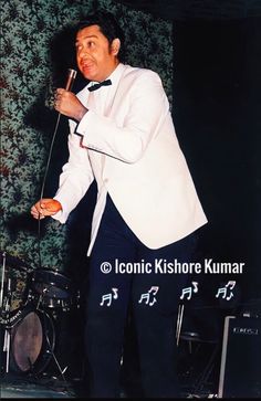 a man in a tuxedo singing into a microphone