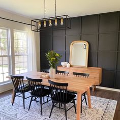 a dining room table with black chairs and a white rug