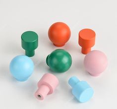 several different colored plastic knobs on a white surface