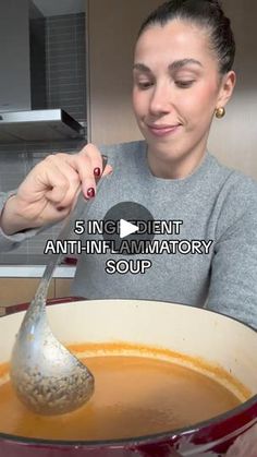 a woman holding a ladle full of soup