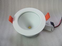 an overhead view of a white downlight with red and black wires on the side