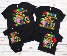 two black onesuits with mario and luigi's birthday shirts on them, sitting next to each other