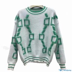 a white sweater with green squares on it