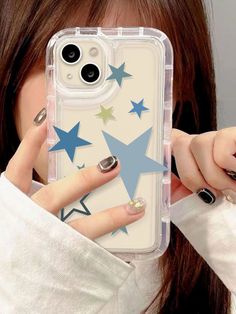 a woman holding up her phone case with stars on it