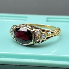 This listing is for garnet ring only ~ Video sows different rings available in our shop which are sold separately . Fabulous antique ~ late Victorian / Art Nouveau~ 14kt solid yellow gold ~ open back faceted deeply colored garnet with three small Old Mine Cut diamonds on each side ~ The sides have leafy design with ornate ring shank . Unmarked but acid tested by professional jeweler for 14kt solid gold . Date: late 19th to early 20th century . Materials: 14K yellow and faceted garnet ( approx si Antique Yellow Gold Sapphire Ring With Rose Cut Diamonds, Victorian Ruby Ring With Center Stone, Antique Red Diamond Ring With Rose Cut Diamonds, Victorian Ruby Ring With Rose Cut Diamonds, Heirloom Garnet Jewelry With Bezel Setting, Heirloom Garnet Ring With Bezel Setting, Ruby Ring With Rose Cut Diamonds, Antique Ruby Diamond Ring Hallmarked, Victorian Ruby Rings In Yellow Gold