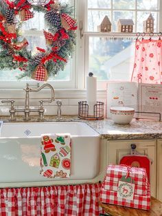 a christmas wreath is hanging on the kitchen window sill next to an old fashioned sink