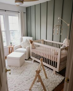 a baby's room with a white crib, chair and couch in it