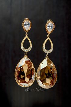 These Wedding earrings are a glamorous and eye catching golden chandelier design.   * Golden Shadow large Swarovski crystal drops * Cubic zirconia ear posts * 14K gold plated settings * 14K gold plated cubic zirconia teardrop connectors * Anti-tarnish gold wire * Approximately 2.5 inches ... Golden Chandelier, Doll Wedding Dress, Diwali Party, Golden Shadow, Chandelier Design, Wedding Item, Gold Wire, Crystal Drop, In Bloom