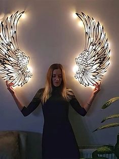 a woman holding two angel wings in front of her face