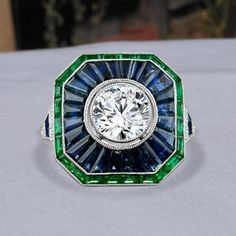 a diamond and emerald ring on a table