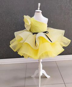 Description: Celebrate your little one's special moments with our stunning One Shoulder Yellow Tutu Dress! Perfect for birthdays, parties, and other festive occasions, this dress combines elegance and sparkle to make your toddler girl shine. ✨ Product Features: Color: Bright and vibrant yellow with glittery accents Design: Elegant one-shoulder design with a fluffy tutu skirt Material: High-quality tulle and soft, breathable fabric for comfort and style Size: Available in various sizes to fit tod Spring Princess Pageant Dress For Birthday, Spring Birthday Princess Pageant Dress, Princess Style Pageant Dress For Spring Birthday, Yellow Princess Dress For Birthday In Spring, Yellow Summer Party Tutu Dress, Princess Dress With Ruffles For Birthday Party, Summer Party Pageant Dress With Ruffles, Tulle Pageant Dress For Party Season, Holiday Birthday Tulle Dress