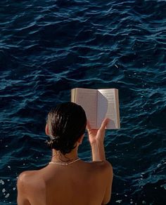 a woman reading a book in the water