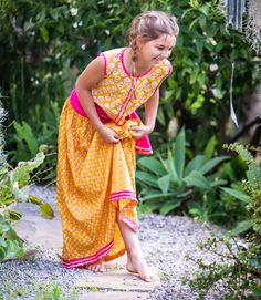 Add a pop of color with our Divya Lehenga! The bright orange and red combination is sure to stand out. The elastic waist adds comfort and the dupata completes the look. Perfect for your little fashionista to stay cool and stylish! Wash cold with like colors Lay flat to dry; Minor shrinkage likely if tumble dried 100% cotton Bohemian Orange Choli For Navratri, Orange Bohemian Choli For Navratri, Yellow Cotton Saree Dress, Cotton Anarkali Choli For Summer, Summer Cotton Anarkali Choli, Summer Anarkali Cotton Choli, Summer Festive Choli With Bandhani Print, Summer Bollywood Cotton Lehenga, Traditional Yellow Summer Choli