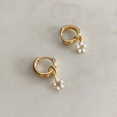 The Daisy Hoops are a necessary addition to your ear stack! A classic huggie hoop with a sweet Daisy dangle.  The Daisy hoops will be your new favourite earrings to brighten up your look! Wear the hoop with the Daisy to update your look or without for the simple classic look, we love options! Finished in high-polish 18k gold filled. 12mm huggie hoop with a 10x5mm Daisy drop. خواتم خطوبة, Daisy Jewelry, Minimal Accessories, Gold Chain With Pendant, Ear Stack, Daisy Earrings, Jewelry Lookbook, Jewelry Inspo, Pretty Jewellery