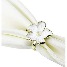 a napkin with a flower on it and a white napkin ring in the middle of it