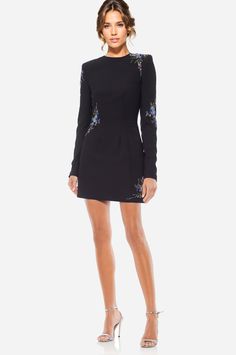 Catching feelings in The Camryn… Who doesn’t love a LBD with some sparkle? We certainly do. The Camryn is the definition of a perfect party dress. Whether you're attending a cocktail party, Thanksgiving, or even Hanukkah, this black mini dress will keep you cozy and feeling like the chicest woman in the room. Its shoulder pads and long sleeves create a polished look, and the embellishments scattered around elevate the dress to a luxurious level. The tulle underskirt adds a subtle throwback bell Formal Evening Embellished Mini Dress, Embellished Dress For Date Night And Party Season, Holiday Formal Embellished Mini Dress, Embellished Fitted Mini Dress For Formal Events, Dressy Embellished Mini Dress For Evening, Dressy Embellished Evening Mini Dress, Elegant Embellished Mini Dress For Date Night, Embellished Dress For Cocktail Holiday Events, Embellished Holiday Cocktail Dress