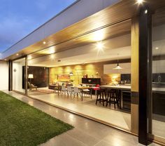 an open living room and dining area in a modern home at night with lights on the ceiling