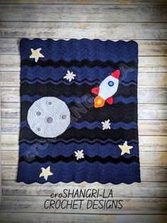 a crocheted blanket with an image of a rocket ship and moon on it