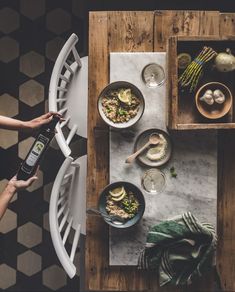 a table with bowls of food on it and a person using an electric blender