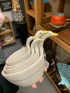 a person holding several white bowls in their hands