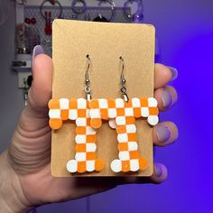 a pair of orange and white checkered earrings