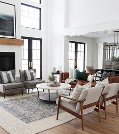 a living room with couches, chairs and a fire place in the middle of it