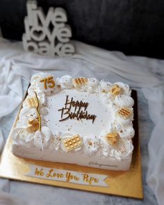 a white and gold birthday cake on a table