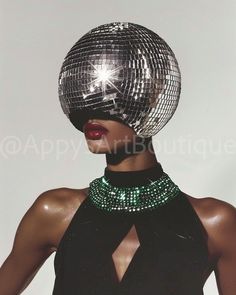 An editorial masterpiece where the model, adorned with a disco ball head and a striking black gown, showcases a green emerald necklace, blending glamour with futuristic fantasy. Metallic Runway Fashion, Disco Chic Party, Disco Black Women, Space Disco Outfit, Disco Embroidery, Black Glamour Aesthetic, Camp Style Fashion, 70s Jewelry Disco, Disco Ball Makeup