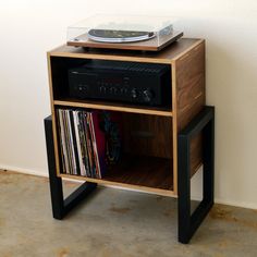 a record player sitting on top of a wooden shelf