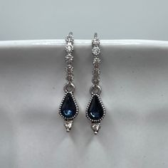 *  Silver-tone ear wire with Cubic Zirconia  *  Dark blue teardrop Cubic Zirconia *  1-inch length  These earrings are crafted to enhance your bridal look with elegance and are suitable for various wedding themes and styles, from classic to contemporary.  Perfect for brides looking to add a touch of color and glamour to their wedding day.  The silver earrings are perfect for the bride seeking a touch of "something blue". Care Instructions: To keep your earrings in pristine condition, avoid conta Blue Elegant Jewelry With Matching Earrings, Traditional Blue Drop Bridal Earrings, Traditional Blue Wedding Earrings, Victorian Blue Earrings For Formal Occasions, Victorian Blue Earrings For Weddings, Dark Blue Earrings, Blue Drop Earrings, Earrings Aesthetic, Prom Earrings