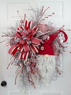 a christmas wreath with santa claus and candy canes hanging on the front door,