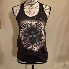 Doodle Bell Boutique Graphic Tee Nwt Size Medium Gray Back Ground T Back Tank Top Saying On The Front “Raising Hell With The Hippies & Cowboys” Featuring Jinks In The Middle Cotton/Polyester Blend Machine Washable Casual Racerback Top With Graphic Print, Cotton Tank Top With Graphic Print For Festivals, Cotton Graphic Print Tank Top For Festivals, Summer Tank Top With Skull Print, Graphic Print Tank Tops For Festivals, Festival Graphic Print Tank Tops, Festival Cotton Top With Graphic Print, Casual Printed Festival Tank Top, Casual Printed Tank Top For Festivals