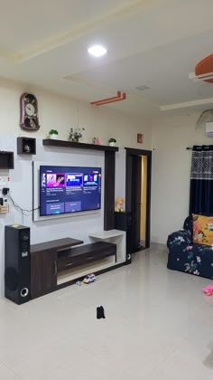 a flat screen tv sitting on top of a wooden entertainment center in a living room