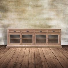 an empty room with a wooden floor and a wall painted in beige color, it has two glass doors on one side and three drawers on the other side