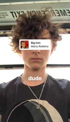 a young man with curly hair wearing a black shirt