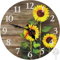 a clock with sunflowers painted on the face and numbers in white, against a wooden background