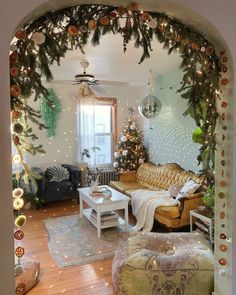 a living room decorated for christmas with lights and decorations on the walls, couches and coffee table