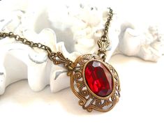 Beautiful victorian style pendant necklace made of a lovely oxidized brass filigree cabochon base, American made, and a vintage ruby red rhinestone cabochon. The size of the cabochon is 13 x 18 mm. The necklength is approximately 49 cm. (19.3 inches) For more jewelry please visit our shop: http://www.minouc.etsy.com For combined shipping please contact us. We also combine shipping with our other Etsy shop where we sell vintage fabrics and finds from Holland and France: http://www.minoucbrocante. Ornate Red Pendant Jewelry, Victorian Brass Necklace For Valentine's Day, Victorian Antique Gold Necklaces For Valentine's Day, Antique Red Necklace For Wedding, Victorian Antique Gold Necklace For Valentine's Day, Ornate Filigree Jewelry For Valentine's Day, Elegant Oval Pendant Necklace With Antique Finish, Red Intricate Design Jewelry For Gift, Victorian Red Jewelry With Vintage Charm