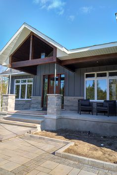 a house that is under construction with windows and doors on the front, patio area