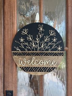 a welcome sign hanging from the side of a wooden door