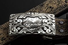 Sterling silver trophy buckle Hand-cute overlay scrolls Lake scenery Articulating hinge 2 7/8" x 1 3/4" Fits all 1.5-inch belt straps Made in the USA Artisan Engraved Belt Buckles As Gift, Artisan Engraved Belt Buckles For Gifts, Rectangular Silver Engraved Belt Buckles, Rectangular Engraved Silver Belt Buckles, Silver Rectangular Engraved Belt Buckles, Silver Engraved Rectangular Belt Buckles, Silver Engraved Belt As Gift, Silver Artisan Belt Buckle With Antique Design, Vintage Silver Engraved Belt