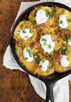 an omelet with sour cream and green onions in a cast iron skillet