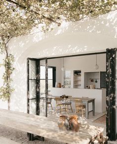 an outdoor dining area with wooden table and chairs