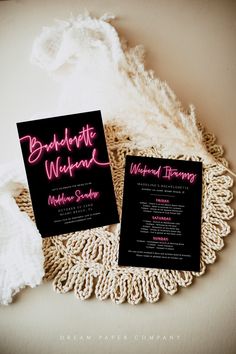 two black and pink wedding stationery cards on a doily with white crochet