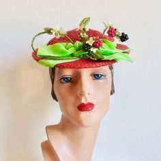 "A very whimsical hat from the 1950's from a well known Hollywood milliner. Made in a red woven synthetic straw. Shallow crown and a small brim. Adorned with faux blackberries, rasberries, and yellow berries as well as small yellow fabric flowers, stems and leaves. Also trimmed with a lime green velvet ribbon around the crown and a bow at the front. Interior hat has a green velvet head holder that anchors to the back of the head. Red grosgrain ribbon trims the inside crown. Label:  Caspar Davis Red Summer Hats For Garden Party, Retro Brimmed Fascinator For Parties, Vintage Brimmed Mini Hats For Party, Retro Curved Brim Costume Hats For Party, Red Retro Hat With Curved Brim, Retro Red Hat With Curved Brim, Retro Red Summer Hats, Retro Red Party Hat, Red Retro Party Hat