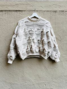 a white sweater hanging on a wall