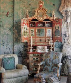 an ornately decorated room with two chairs and a dresser