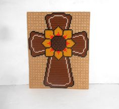 a cross made out of woven material with a sunflower on the front and center