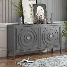 a grey sideboard with an art piece on top